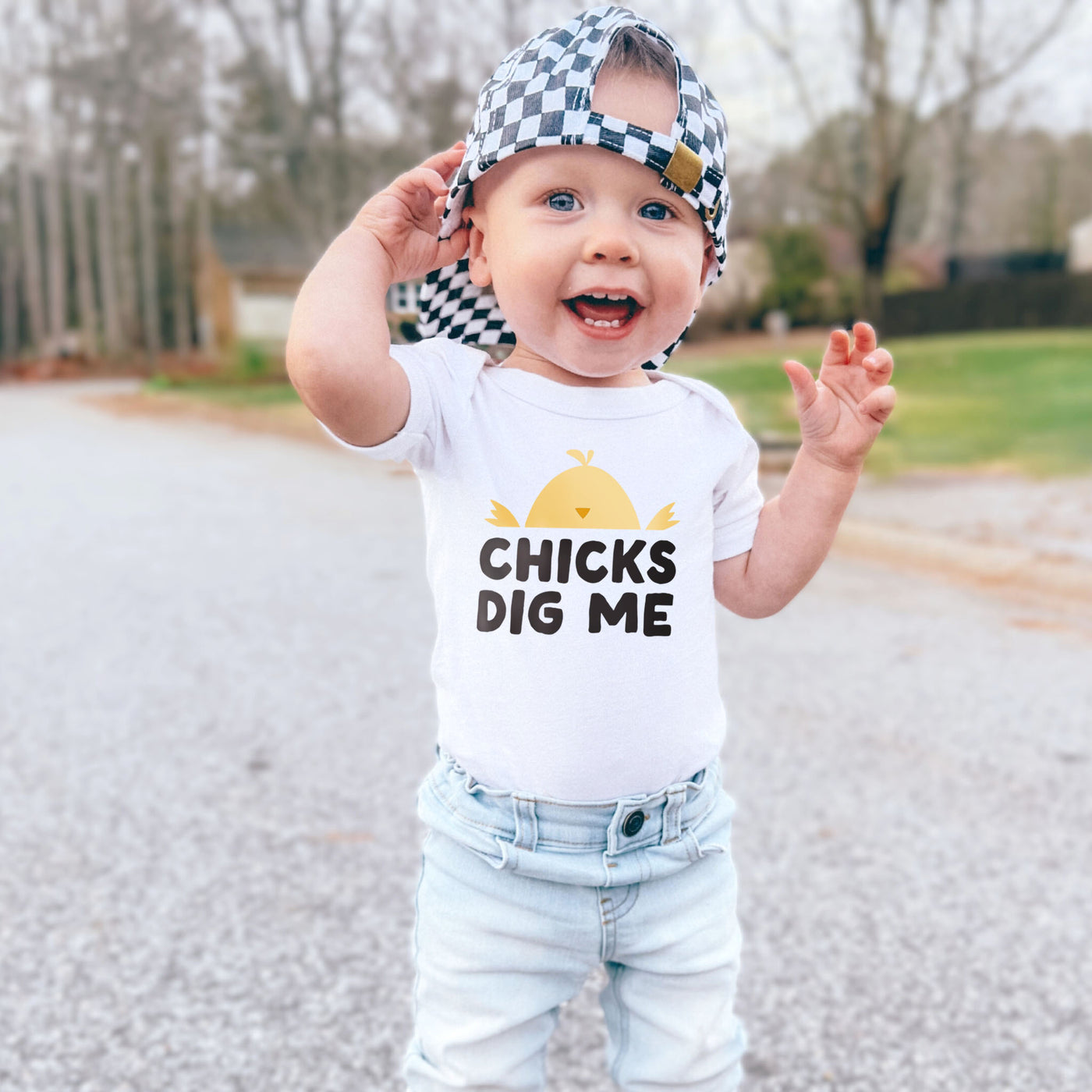 little boy wearing white short sleeve onesie bodysuit graphic tee with light yellow, orange and black chick digs me with baby chick design